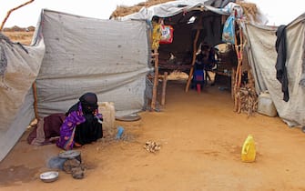 The mother of Samar Ali Jaidi, a seven-year-old girl suffering from malnutrition, prepares food at a make-shift camp for displaced Yemenis who fled fighting between the Huthi rebels and the Saudi-backed government, in the Abs district of the northwestern Hajjah province on September 28, 2109. - The girl's family reportedly can not afford the cost of transportation to the nearest health centre. (Photo by ESSA AHMED / AFP)        (Photo credit should read ESSA AHMED/AFP via Getty Images)