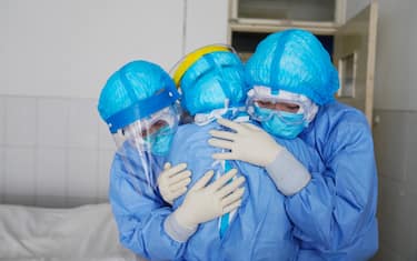 This photo taken on January 28, 2020 shows medical staff members hugging each other in an isolation ward at a hospital in Zouping in China's easter Shandong province. - China faced deepening isolation over its coronavirus epidemic on February 1 as the death toll soared to 259, with the United States leading a growing list of nations to impose extraordinary Chinese travel bans. (Photo by STR / AFP) / China OUT (Photo by STR/AFP via Getty Images)