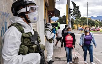 BOGOTA, COLOMBIA - JULY 13: Soldiers in protective gears amid the COVID-19 pandemic stand guard in neighbourhood of Ciudad Bolivar on July 13, 2020 in Bogota, Colombia. While some areas of the city will remain open with restrictions, others will be on strict lockdown. Bogota starts today a zonal rotating system. The city was divided in areas, which will be closed in determined dates, to reduce the circulation of people and hospital occupation. Government also announced economic aid to those in need. (Photo by Guillermo Legaria/Getty Images)