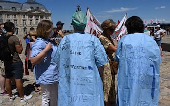 A man wears a suit reading "Segur is a scam" as health care workers demonstrate in Bordeaux on July 14, 2020, against the wage agreements as part of the 'Segur de la Sante' (general talks on Health reforms) aimed at improving working conditions, salaries and patient care in the medical sector. - Health care workers are protesting in France on the country's National day to demand more for their sector a day after the government and unions signed an agreement giving over eight billion euros in pay rises, with the prime minister admitting the move was overdue in view of the coronavirus pandemic. (Photo by MEHDI FEDOUACH / AFP) (Photo by MEHDI FEDOUACH/AFP via Getty Images)