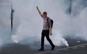 A protester raises a fist during a demonstration in Paris, on July 14, 2020, as part of a nationwide day of protests by health workers to demand better work conditions. - Health care workers are protesting in France on the country's National day to demand more for their sector a day after the government and unions signed an agreement giving over eight billion euros in pay rises, with the prime minister admitting the move was overdue in view of the coronavirus pandemic. (Photo by Zakaria ABDELKAFI / AFP) (Photo by ZAKARIA ABDELKAFI/AFP via Getty Images)