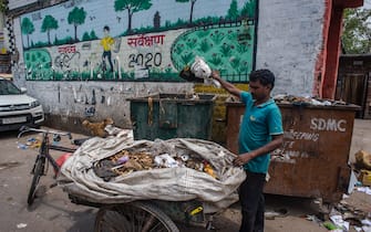 NEW DELHI, INDIA - JULY 14: An Indian ragpicker collects valuable waste items from a dumping site on July 14, 2020  in New Delhi, India.  With over 900,000 confirmed cases and 23,000 deaths, environmental and health experts have warned that India, which is currently the third worst COVID19-affected country, could face further challenges in tackling the impact of the global pandemic if immediate steps are not taken for the proper disposal of masks, gloves, personal protective equipment and other waste materials. (Photo by Yawar Nazir/Getty Images)
