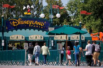 PARIS, FRANCE - JULY 13: People with annual passes wearing protective face masks arrive to visit Disneyland Paris on July 13, 2020 in Marne-la-Vallee, near Paris, France. After four months of closure, the amusement park officially reopens its doors on Wednesday July 15 with compulsory reservations online. The Disneyland Paris and Walt Disney studio parks have been closed since mid-March due to the coronavirus epidemic (COVID 19). (Photo by Chesnot/Getty Images)