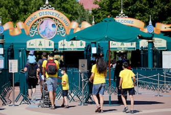 1255903730 PARIS, FRANCE - JULY 13: People with annual passes wearing protective face masks arrive to visit Disneyland Paris on July 13, 2020 in Marne-la-Vallee, near Paris, France. After four months of closure, the amusement park officially reopens its doors on Wednesday July 15 with compulsory reservations online. The Disneyland Paris and Walt Disney studio parks have been closed since mid-March due to the coronavirus epidemic (COVID 19). (Photo by Chesnot/Getty Images)