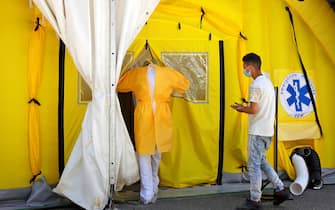 SPAIN PANDEMIC CORONAVIRUS COVID19 epa08549942 A health worker (L) and a patient enter into a field hospital that was recently built in Lleida, Catalonia, Spain, 16 July 2020. Regional authorities announced special movement restriction measures in the area of Segria in Lleida due to a coronavirus outbreak. EPA/Susanna Saez
