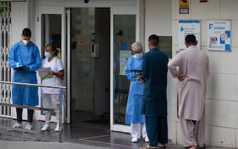epa08549512 Residents stand in a queue to have a treatment outside the health primary center in the district of La Florida, in the city of L'Hospitalet, Barcelona, northeastern Spain, 16 July 2020. Catalan authorities carried out several special measures to avoid the spreading of the virus after a COVID-19 outbreak were registered in three suburbs of L'Hospitalet, the second most populated city of Catalonia.  EPA/ENRIC FONTCUBERTA