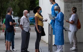 epa08549513 Residents stand in a queue to have a treatment outside the health primary center in the district of La Florida, in the city of L'Hospitalet, Barcelona, northeastern Spain, 16 July 2020. Catalan authorities carried out several special measures to avoid the spreading of the virus after a COVID-19 outbreak were registered in three suburbs of L'Hospitalet, the second most populated city of Catalonia.  EPA/ENRIC FONTCUBERTA