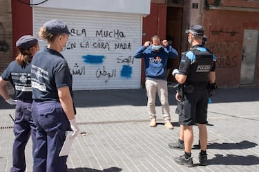 epa08549943 Police officers ask a man to wear a protective face mask in Lleida, Catalonia, Spain, 16 July 2020. Regional authorities announced special movement restriction measures in the area of Segria in Lleida due to a coronavirus outbreak. EPA/Ramon Gabriel