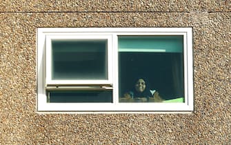 MELBOURNE, AUSTRALIA - JULY 17: A woman looks out of a window at the Alfred Street Public Housing Complex in North Melbourne on July 17, 2020 in Melbourne, Australia. Metropolitan Melbourne and the Mitchell shire are currently in lockdown following the rise in COVID-19 cases through community transmissions. The new restrictions came into effect on Thursday 9 July, with residents in lockdown areas under stay at home orders until 19 August. People are only able to leave home have for exercise or work, to buy essential items including food or to access childcare and healthcare. (Photo by Darrian Traynor/Getty Images)