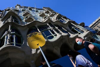 Visitors queue outside Spanish architect Antonio Gaudi's Casa Batllo on July 1, 2020 in Barcelona, on the first day it reopens to the public after more than three months of closure amid the new coronavirus pandemic. (Photo by LLUIS GENE / AFP) (Photo by LLUIS GENE/AFP via Getty Images)