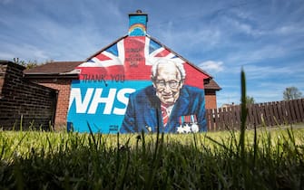 TOPSHOT - A street art graffiti mural, showing the logo of the NHS (National Health Service), and an image 100-year-old veteran Captain Tom Moore who raised over GBP 30 million for NHS charities, is pictured in east Belfast on May 5, 2020. - The number of people killed by the coronavirus in the UK stands at 32,313, according to official figures on May 5 2020, the second highest death toll in the world. Figures from the Office for National Statistics showed Britain had now overtaken Italy, which has reported 29,029 fatalities, and now only stands behind the US with 68,700 deaths, the largest single-country toll. (Photo by Paul Faith / AFP) (Photo by PAUL FAITH/AFP via Getty Images)