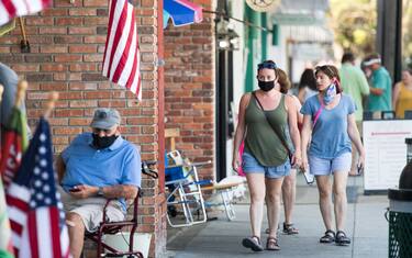 ST. SIMONS ISLAND, GA - JULY 17: People walk down the sidewalk on July 17, 2020 in St. Simons Island, Georgia. Georgia Gov. Brian Kemp made an order earlier in the week that forbade municipal officials from setting mandatory face-covering policies. (Photo by Sean Rayford/Getty Images)