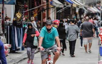 RIO DE JANEIRO, BRAZIL - JULY 16: A man cycles by the Saara region, a large shopping area in the center of the city amidst the coronavirus (COVID-19) pandemic on July 16, 2020 in Rio de Janeiro, Brazil. Brazil is reaching two million confirmed cases of coronavirus (COVID-19). The country is second only to the United States in number of cases and deaths. According to the Brazilian Health Ministry, Brazil has over 76.600 deaths. (Photo by Luis Alvarenga/Getty Images)