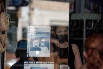 epa08556061 A woman wearing a face mask is seen inside a shop in the island of Menorca, Balearic Islands, eastern Spain, 20 July 2020. The use of face mask in urban areas will be imposed in Balearic Islands from 21 July to avoid the spreading of COVID-19 disease.  EPA/DAVID ARQUIMBAU SINTES