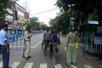 Policemen stop motorists on a street after a new lockdown was imposed as a preventive measure against the spread of the COVID-19 coronavirus, in Siliguri on July 19, 2020. - India on July 17 became the third country in the world to record one million coronavirus cases, following Brazil and the United States where infections also continued to surge. (Photo by Diptendu DUTTA and DIPTENDU DUTTA / AFP) (Photo by DIPTENDU DUTTA/AFP via Getty Images)
