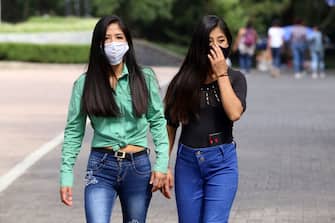 MEXICO CITY, MEXICO - JULY 19: Two women, wearing protective face masks, walk on a street at 'Chapultepec' on July 19, 2020 in Mexico City, Mexico. While most of the Mexican States remain in orange color level, some activities considered non essential are now allowed by the government and the 'new normal' is gradually assimilated by society. (Photo by AdriÃ¡n Monroy/Medios y Media/Getty Images)