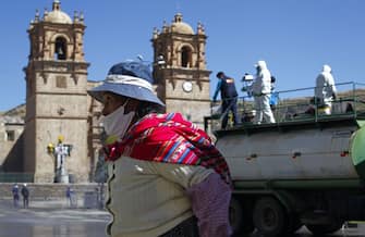 Municipal workers disinfect the main streets of Puno, in the highlands of Peru close to the border with Bolivia, on July 17, 2020 due to an increase of COVID-19 cases - Peru's government has come under heavy criticism for its management of the health crisis, which has left 333,000 people infected, the second most in Latin America, and more than 12,00 dead -- the third highest toll in the region. (Photo by Carlos MAMANI / AFP) (Photo by CARLOS MAMANI/AFP via Getty Images)