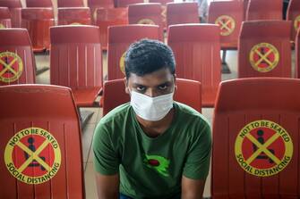 TOPSHOT - A passenger sits next to signs requesting to maintain social distancing as a preventive measure against the spread of the COVID-19 coronavirus at the Hazrat Shahjalal International Airport in Dhaka on June 25, 2020. (Photo by MUNIR UZ ZAMAN / AFP) (Photo by MUNIR UZ ZAMAN/AFP via Getty Images)