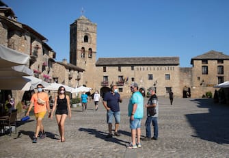 AINSA, SPAIN - JULY 19: Several tourists with masks walk through the town of Ainsa on July 19, 2020 in Ainsa, Spain. The use of masks is mandatory throughout the community of Aragon to stop the spread of the coronavirus (COVID-19). (Photo by Alvaro Calvo /Getty Images)