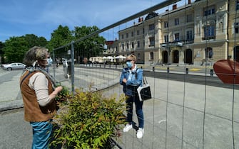 GORIZIA, ITALY - MAY 08:  (L) Anna meets (R)Jozica in front of the wire mesh that divides Piazza Transalpina (Transalpina Square) on May 8, 2020 in Gorizia, Italy. Piazza Transalpina is a square divided between the municipalities of Gorizia in Italy and Nova Gorica in Slovenia. In 1947, the new border created between Italy and Yugoslavia was traced by dividing the square in two, crossed by the so-called "Muro di Gorizia". From May 1, 2004, with the entry of Slovenia into the European Union, the wall dividing the square was removed, but from March 11, 2020 the Slovenian government closed its borders with Italy to counter the spread of the coronavirus. A wire mesh has been positioned on the square to delimit the border between Italy and Slovenia, dividing many families, friends and couples.  (Photo by Pier Marco Tacca/Getty Images)