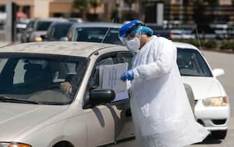 A laboratory worker gives directions to customers at the Certus Lab's COVID-19 drive-in test centre at the parking lot of the Caliente multipurpose complex in Tijuana, Baja California State, Mexico, on July 21, 2020 amid the novel coronavirus pandemic. - As Mexico's public health COVID-19 testing rate is one of the lowest worldwide, private laboratories running certified testing have become an option for people that can afford it. (Photo by Guillermo ARIAS / AFP) (Photo by GUILLERMO ARIAS/AFP via Getty Images)