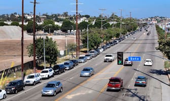 1227727463 A long line of vehicles is seen waiting to enter a COVID-19 test site in Los Angeles, California on July 21, 2020. - California on July 21 reported a total of 400,769 COVID-19 cases since the pandemic began, approaching the numbers of New York, the state with the most cases. (Photo by Frederic J. BROWN / AFP) (Photo by FREDERIC J. BROWN/AFP via Getty Images)