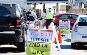 A traffic officer directs vehicles at a COVID-19 test site in Los Angeles, California on July 21, 2020. - California on July 21 reported a total of 400,769 COVID-19 cases since the pandemic began, approaching the numbers of New York, the state with the most cases. (Photo by Frederic J. BROWN / AFP) (Photo by FREDERIC J. BROWN/AFP via Getty Images)