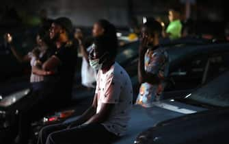 Spectators watch sitting on the hood of their parked cars a stage play called Pidgin English "Grip am" (Hold it) at a drive-in theatre in Abuja on May 30, 2020 as lockdown restrictions to contain the outbreak of COVID-19 coronavirus are relaxed in the country. (Photo by Kola Sulaimon / AFP) (Photo by KOLA SULAIMON/AFP via Getty Images)