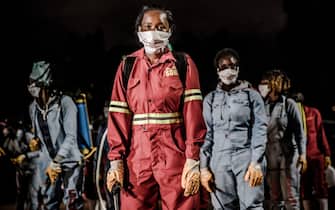 Members of a privately-funded NGO working with county officials wearing protective gather on April 15, 2020, during the dusk-to-dawn curfew imposed by the Kenyan Government, to receive instructions on how to fumigate and disinfect the streets and the stalls at Parklands City Park Market in Nairobi to help curb the spread of the COVID-19 coronavirus. - With a current official number of 225 confirmed coronavirus cases, Kenya has so far cordoned off the capital and parts of its coastline and imposed a curfew and other social distancing measures as part of the country efforts to control the spread of the virus. (Photo by LUIS TATO / AFP) (Photo by LUIS TATO/AFP via Getty Images)