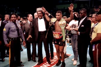 ATLANTIC CITY, NJ - JUNE 27:  Boxing Promoter Don King holds up Boxer Iron Mike Tyson's hand in victory with his championship belt after knocking out Opponent Michael Spinks at Convention Hall in Atlantic City, New Jersey June 27 1988. (Photo by Jeffrey Asher/ Getty Images)