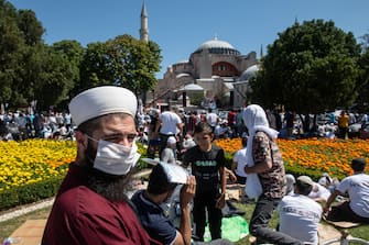 1257921109 ISTANBUL, TURKEY - JULY 24: People gather before the first official Friday prayers outside Hagia Sophia Mosque on July 24, 2020 in Istanbul, Turkey. Turkey's President Recep Tayyip Erdogan attended the first Friday prayer inside the Hagia Sophia Mosque after it was officially reconverted into a mosque from a museum. The controversial decision to change the iconic buildings status came after Turkey's highest administrative court voted on July, 10 to revoke the structures status as a museum allowing it to be converted back to a mosque. Throughout it's history the UNESCO World Heritage site has served as a Byzantine Cathedral, a mosque under Ottoman rule, and most recently a museum. Thousands of worshippers from all over Turkey flocked to the site for the chance to pray inside the historic building for the first Friday prayers. (Photo by Burak Kara/Getty Images)