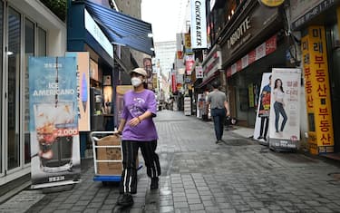 A woman pulls a cart at a shopping district in Seoul on July 23, 2020. - South Korea's economy recorded its worst performance in more than 20 years in the second quarter, the central bank said on July 23, as the coronavirus pandemic hammered its exports. (Photo by Jung Yeon-je / AFP) (Photo by JUNG YEON-JE/AFP via Getty Images)