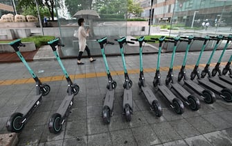 A woman walks past electric kickboards parked on a street in central Seoul on July 23, 2020. - South Korea's economy recorded its worst performance in more than 20 years in the second quarter, the central bank said on July 23, as the coronavirus pandemic hammered its exports. (Photo by Jung Yeon-je / AFP) (Photo by JUNG YEON-JE/AFP via Getty Images)