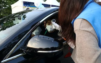 SEOUL, SOUTH KOREA - JULY 17: A event staff checks the temperature of audience while enter at a drive-in concert as South Koreans take measures to protect themselves against the spread of coronavirus (COVID-19) on July 17, 2020 in Seoul, South Korea. South Korea's new daily virus cases came in at around 60 for the second straight day on Friday as the country grapple with rising imported cases and an uptick in local infections. The country added 60 cases tody, including 21 local infections, raising the total caseload to 13,672, according to the Korea Centers for Disease Control and Prevention (KCDC). (Photo by Chung Sung-Jun/Getty Images)