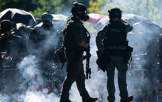 SEATTLE, WA - JULY 25: Firecrackers go off near members of a police SWAT team during protests in Seattle on July 25, 2020 in Seattle, Washington. Police and demonstrators clash as protests continue in the city following reports that federal agents may have been sent to the city. (Photo by David Ryder/Getty Images)
