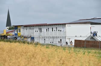 Exterior view shows the accommodation containers of a farm's seasonal workers that are secured from the outside world with a fence on July 27, 2020  in Mamming, southern Germany, after an outbreak of COVID-10 coronavirus cases has raised. - At least 174 seasonal workers have tested positive for the virus on the farm in the municipality of Mamming, most of them from Hungary, Romania, Bulgaria and Ukraine, and some 500 workers were sent into quarantine on the Bavarian farm at the weekend to contain a mass coronavirus outbreak. (Photo by Christof STACHE / AFP) (Photo by CHRISTOF STACHE/AFP via Getty Images)
