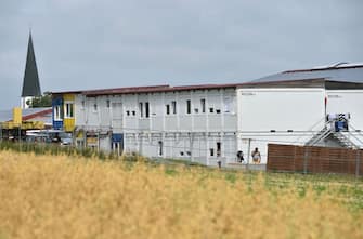 1227797737 Exterior view shows the accommodation containers of a farm's seasonal workers that are secured from the outside world with a fence on July 27, 2020 in Mamming, southern Germany, after an outbreak of COVID-10 coronavirus cases has raised. - At least 174 seasonal workers have tested positive for the virus on the farm in the municipality of Mamming, most of them from Hungary, Romania, Bulgaria and Ukraine, and some 500 workers were sent into quarantine on the Bavarian farm at the weekend to contain a mass coronavirus outbreak. (Photo by Christof STACHE / AFP) (Photo by CHRISTOF STACHE/AFP via Getty Images)