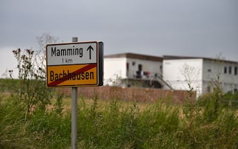 The village exit sign is pictured as on the background the accommodations of the farm's seasonal workers are seen, in the municipality of Mamming where an outbreak of COVID-10 coronavirus cases has raised, on July 26, 2020. - A total of 174 seasonal workers on a large Bavarian farm in the municipality of Mamming have tested positive for the coronavisrus COVID-19 and some 500 are in quarantine to contain a mass coronavirus outbreak. (Photo by Christof STACHE / AFP) (Photo by CHRISTOF STACHE/AFP via Getty Images)