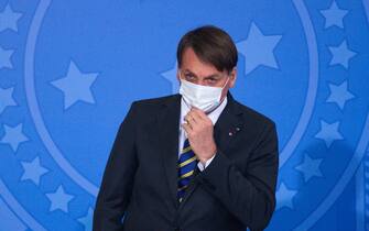 BRASILIA, BRAZIL - JULY 29: Brazilian President Jair Bolsonaro puts his hand on the protective mask during the launch of the Rural Women Campaign amidst the coronavirus (COVID-19) pandemic at the Palacio do Planalto on July 29, 2020 in Brasilia. Bolsonaro was infected by Covid-19 and was in quarantine until last Saturday (25). Brazil has over 2.483,000 confirmed positive cases of Coronavirus and has over 88,539 deaths. (Photo by Andressa Anholete/Getty Images)