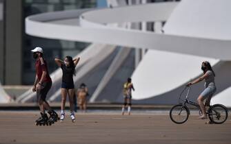 epa08567874 People play and do sports next to the National Museum of the Republic in Brasilia, Brazil, 26 July 2020.  EPA/Andre Borges