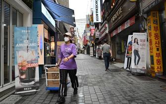 A woman pulls a cart at a shopping district in Seoul on July 23, 2020. - South Korea's economy recorded its worst performance in more than 20 years in the second quarter, the central bank said on July 23, as the coronavirus pandemic hammered its exports. (Photo by Jung Yeon-je / AFP) (Photo by JUNG YEON-JE/AFP via Getty Images)