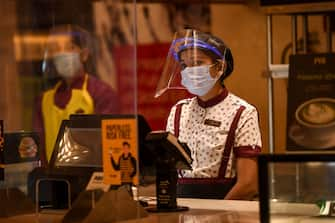 PVR Cinemas employees wearing face shields, gloves and facemasks, participate in a sanitisation work as part of preparations for a possible reopening amid concerns over the spread of the COVID-19 coronavirus, in New Delhi on July 31, 2020. (Photo by Prakash SINGH / AFP) (Photo by PRAKASH SINGH/AFP via Getty Images)