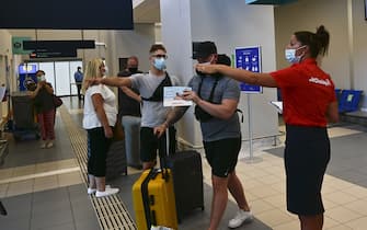 1256428039 ZAKYNTHOS, GREECE - JULY 15: Passengers of a flight from United Kingdom wearing protective face masks arrive at the Zakinthos Airport on Zakinthos Island on July 15, 2020 in Zakynthos, Greece. (Photo by Milos Bicanski/Getty Images)