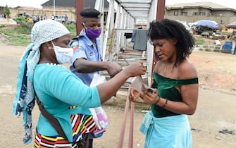 1211735035 A policeman instructs a lady to wear face mask at a checkpoint in compliance with state directive to curb the spread of COVID-19 coronavirus at Ojodu-Berger in Lagos, on May 4, 2020. - Kano, with around 12 million people, is the second most populous state in Nigeria. The Nigeria Centre for Disease Control on May 1, 2020, said the number of recorded infections across Kano rose to 219, up from 77 at the start of the week.
Kano has in recent days seen a spate of high-profile deaths including academics, bureaucrats, businessmen and traditional leaders. (Photo by PIUS UTOMI EKPEI / AFP) (Photo by PIUS UTOMI EKPEI/AFP via Getty Images)