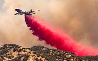 TOPSHOT - The 747 Supertanker makes a retardant drop on a ridge as firefighters continue to battle the Apple fire near Banning, California on August 1, 2020. - 4,125 acres have burn in Cherry Valley, about 2,000 people have received evacuation orders in the afternoon of August 1. (Photo by JOSH EDELSON / AFP) (Photo by JOSH EDELSON/AFP via Getty Images)