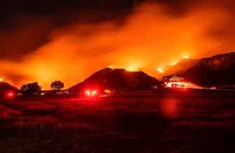 TOPSHOT - In this long exposure photograph, firefighters monitor flames as they skirt a hillside near a residential area during the Apple fire in Banning, California on August 1, 2020. - 4,125 acres have burn in Cherry Valley, about 2,000 people have received evacuation orders in the afternoon of August 1. 
Around 8PM the fire spread to 12,000 acres. (Photo by JOSH EDELSON / AFP) (Photo by JOSH EDELSON/AFP via Getty Images)