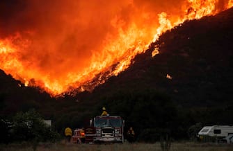 TOPSHOT - Firefighters watch as flames approach a retardant line near a residential community during the Apple fire in Banning, California on August 1, 2020. - 4,125 acres have burn in Cherry Valley, about 2,000 people have received evacuation orders in the afternoon of August 1. 
Around 8PM the fire spread to 12,000 acres. (Photo by JOSH EDELSON / AFP) (Photo by JOSH EDELSON/AFP via Getty Images)