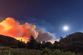 CHERRY VALLEY, CA - AUGUST 01: Flames approach on a western front of the Apple Fire, consuming brush and forest under a nearly full moon during an excessive heat warning on August 1, 2020 in Cherry Valley, California. The fire began shortly before 5 p.m. the previous evening, threatening a large number of homes overnight and forcing thousands to flee before exploding to 12,000 acres this afternoon, mostly climbing the steep wilderness slopes of the San Bernardino Mountains.  (Photo by David McNew/Getty Images)