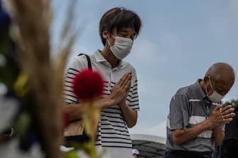 1227930107 HIROSHIMA, JAPAN - AUGUST 06: People pray in remembrance during the 75th anniversary of the Hiroshima atomic bombing, on August 6, 2020 in Hiroshima, Japan. In a ceremony that has been scaled back significantly because of Covid-19 coronavirus, Japan will mark the 75th anniversary of the first atomic bomb that was dropped by the United States on Hiroshima on August 6, 1945. The bomb instantly killed an estimated 70,000 people and thousands more in coming years from radiation effects. Three days later the United States dropped a second atomic bomb on Nagasaki which ended World War II. (Photo by Carl Court/Getty Images)