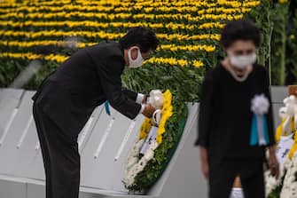 1227929759 HIROSHIMA, JAPAN - AUGUST 06: Japanese Prime Minister, Shinzo Abe, lays a wreath during the 75th anniversary of the Hiroshima atomic bombing, on August 6, 2020 in Hiroshima, Japan. In a ceremony that has been scaled back significantly because of Covid-19 coronavirus, Japan will mark the 75th anniversary of the first atomic bomb that was dropped by the United States on Hiroshima on August 6, 1945. The bomb instantly killed an estimated 70,000 people and thousands more in coming years from radiation effects. Three days later the United States dropped a second atomic bomb on Nagasaki which ended World War II. (Photo by Carl Court/Getty Images)